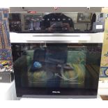 A Miele (unused) integrated electric wall oven with a part brushed stainless steel front 23.