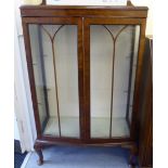 A 1930s walnut bow front display cabinet with two glazed doors,