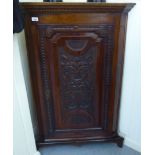 An early/mid 19thC stained oak corner cabinet of slender proportions with a floral carved,