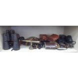 Various pair of binoculars and field glasses; and a Victorian style brass desk top,