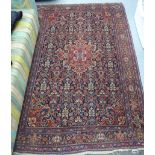 A Persian rug, profusely decorated with stylised flora,