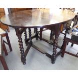 A 1930s oak drop leaf dining table with an end drawer,