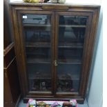 A 1920s stained oak display cabinet with a pair of glazed doors, enclosing four shelves,
