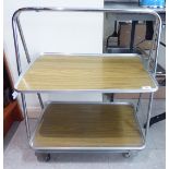 A 1970s wood effect laminate and chromium plated, tubular steel, two tier trolley,