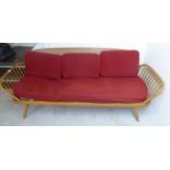 An Ercol beech and elm framed day bed with a lozenge shaped backboard,