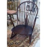 An Ercol dark stained beech and elm framed hoop and spindled back rocking chair,