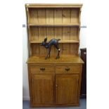 An early 20thC waxed pine farmhouse style dresser, the superstructure with two open plate racks,