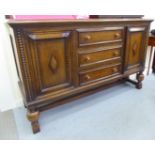 A 1930s oak sideboard with three drawers and two doors,