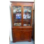 A modern Georgian style mahogany finished cabinet bookcase with a dentil moulded cornice,