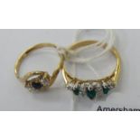 Two yellow metal rings, one set with emeralds and diamonds,