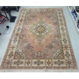 A Louis de Poortere Mossoul carpet on a salmon pink and peach coloured ground 139'' x 99''