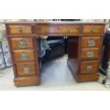 A late Victorian mahogany nine drawer, twin pedestal desk, the top set with a brown hide scriber,