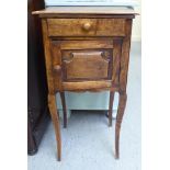 A late 19thC French oak bedside cabinet with a drawer and a panel,