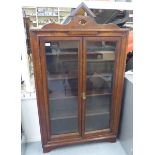 A 1920s stained oak display cabinet with a pair of glazed doors, enclosing four shelves,
