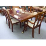 A modern mahogany finished twin pedestal dining table, raised on splayed,