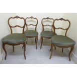 A set of four late 19thC French walnut framed salon chairs with rococo inspired, carved,