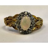 An 18ct gold ring, claw set with an opal, surrounded by diamonds,