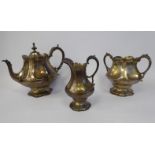 An early Victorian three piece engraved silver tea set of lobed, bulbous,