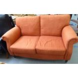A John Lewis two person settee, upholstered in red fabric,