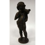 A late 19thC cast and patinated bronze figure, a standing demure cherub,