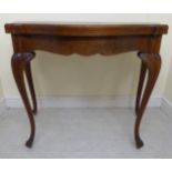 A late 19thC Continental oak tea table with a bow front and foldover top,