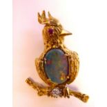 A gold coloured metal novelty brooch, a bird perched on a branch, set with an opal,