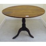 A George III oak tip-top pedestal table, over a ring turned baluster column,