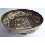 An early 20thC Satsuma earthenware shallow footed bowl, decorated with figural and floral vignettes,
