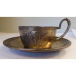 An early 20thC WMF white metal tea cup and saucer with stiff leaf and berry,