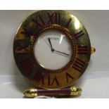 A Cartier lacquered brass cased quartz travellers timepiece of circular compact design with a