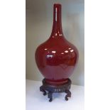 A 20thC Chinese sang-du-boeuf glazed porcelain bottle vase of bulbous form with a long,