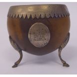 An early 19thC coconut shell bowl with an applied white metal frilled rim and engraved armorial on
