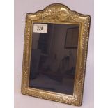 A glazed silver photograph frame with embossed neo-classical ornament,