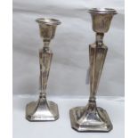 Two similar silver candlesticks, each with a waisted, tapered column,