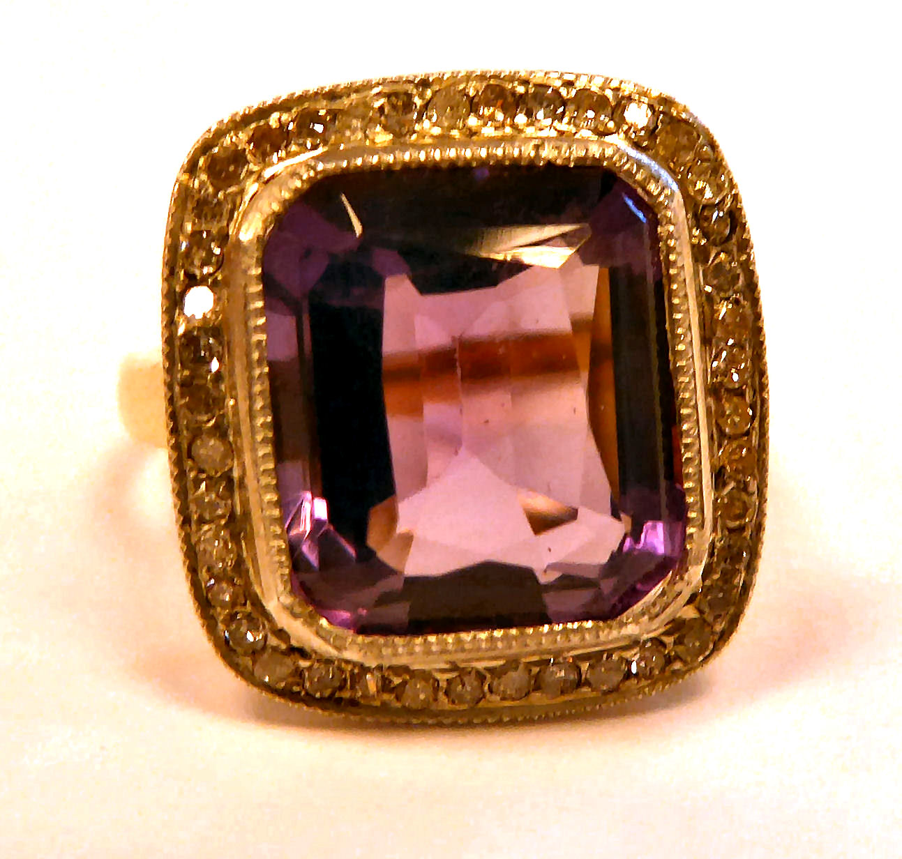 A gold coloured metal ring, set with an amethyst,