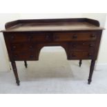 A late Victorian mahogany six drawer, kneehole washstand, raised on ring turned,