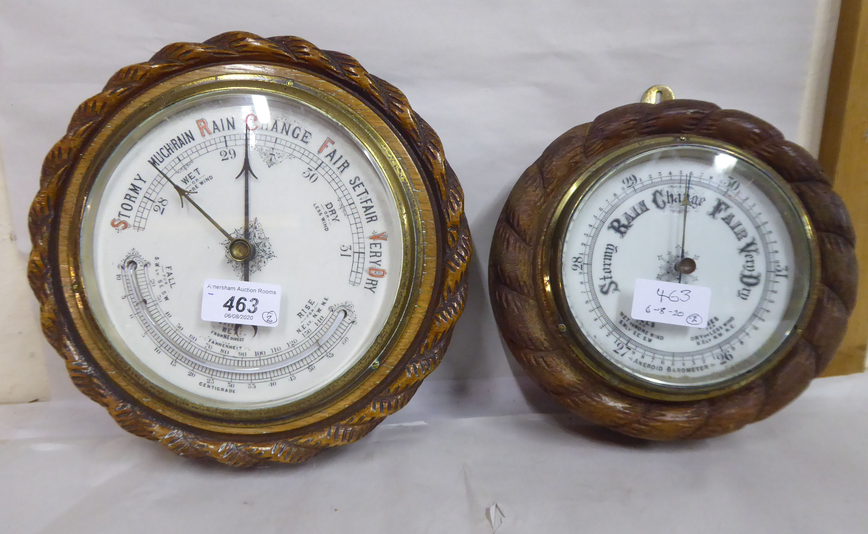 Two 1930s oak cased barometers, each with a carved ropetwist border and an enamelled dial 8'' & 9.