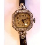 A diamond encrusted white coloured metal, octagonal cased cocktail watch, faced by an Arabic dial,
