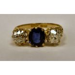 An 18ct gold three stone ring, claw set with a sapphire,