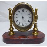 A late 19thC lacquered brass cased desk timepiece, faced by an enamelled Roman dial,