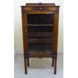 A 1930s stained oak display cabinet with a glazed door, enclosing three shelves,