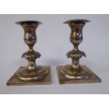 A pair of Continental white metal dwarf candlesticks,