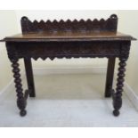 A late Victorian carved stained oak hall table with a low galleried back, over two frieze drawers,