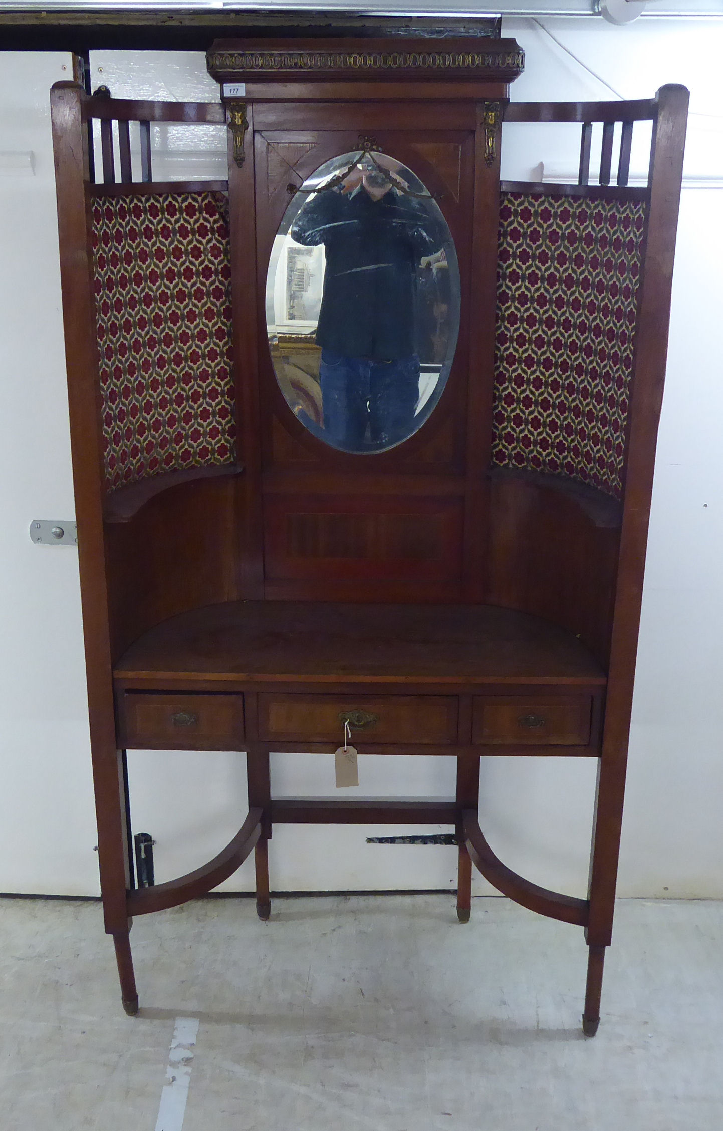 An Edwardian mahogany hallstand of concave form with a mirrored panel,