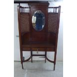 An Edwardian mahogany hallstand of concave form with a mirrored panel,
