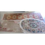 Three woollen rugs: to include an oval Chinese washed example,