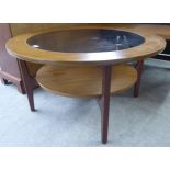 A 1970s/80s teak finished two tier coffee table with an inset glass top tier,