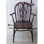 A mid 20thC beech and elm framed, low hoop and spindled wheelback Windsor elbow chair,