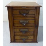 An early 20thC light oak four drawer desktop pedestal filing cabinet with side action lockable