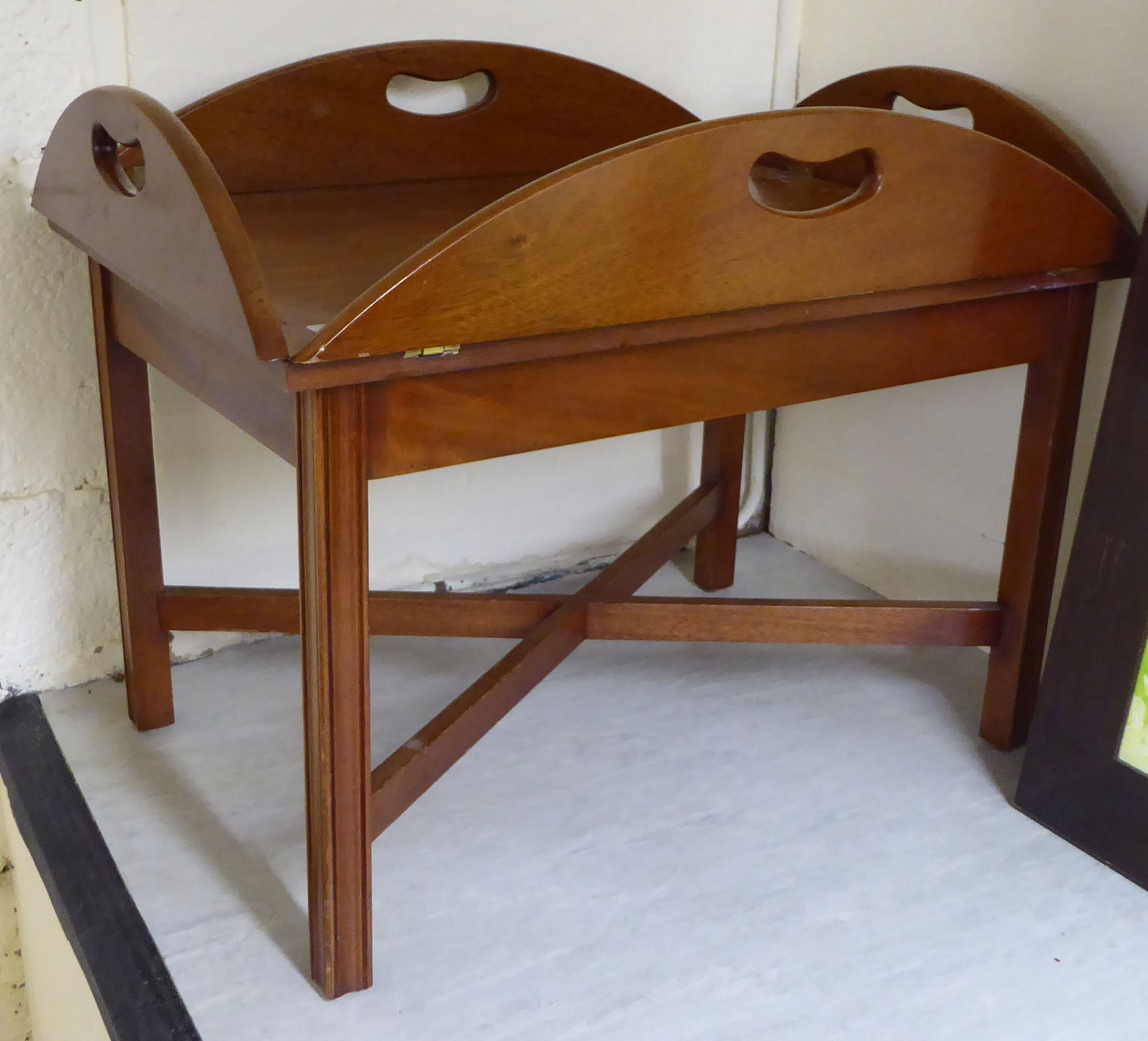 A modern reproduction of a late Victorian mahogany butler's tray with folding flaps and cut-out